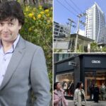 O empresário Chris Webster posando em frente a um arbusto florido amarelo.