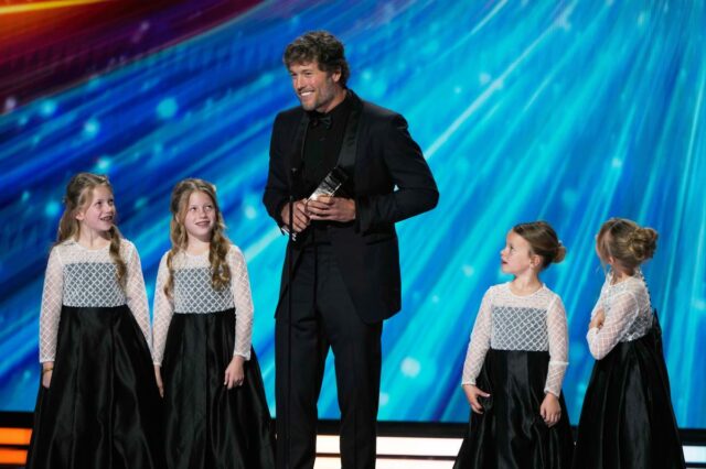 Matthew Stafford aceitando o prêmio de Jogador Mais Valioso da AP com quatro meninas.