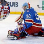 O goleiro do New York Rangers, Jonathan Quick (32), desviando o disco durante um jogo contra o Carolina Hurricanes.