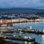 O regulador da Ilha de Man multa a operadora de jogos de azar em US$ 273 mil por falhas de AML. Paisagem urbana da Ilha de Man à noite perto do porto