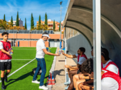 Regulador de jogos de azar francês ANJ alerta sobre preocupações com aumento de anúncios de apostas na Copa do Mundo O regulador francês de jogos de azar, ANJ, alerta sobre preocupações crescentes com anúncios de apostas na Copa do Mundo. Um treinador de futebol distribui garrafas de água para jogadores que usam babadores vermelhos enquanto eles se sentam no banco durante um intervalo em um campo ensolarado ao ar livre, com um jogador próximo segurando garrafas adicionais.