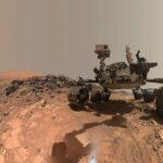 O rover Curiosity Mars da NASA é visto no local de onde desceu para perfurar um alvo rochoso chamado 'Buckskin' na parte inferior do Monte Sharp neste autorretrato de baixo ângulo tirado em 5 de agosto de 2015 e divulgado em 19 de agosto de 2015. A selfie combina várias imagens componentes tiradas pelo Mars Hand Lens Imager (MAHLI) da Curiosity.