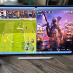 The Samsung Galaxy Tab S11 Ultra in a living room setting with a blue controller next to it