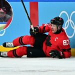 Sidney Crosby, do Canadá, reagindo após sofrer uma lesão durante um jogo olímpico de hóquei no gelo.