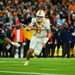 O quarterback do Tennessee Volunteers, Joey Aguilar (6), corre a bola para um touchdown contra o Illinois Fighting Illini durante o primeiro tempo no Nissan Stadium.