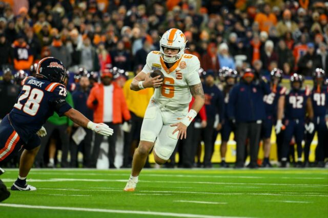 O quarterback do Tennessee Volunteers, Joey Aguilar (6), corre a bola para um touchdown contra o Illinois Fighting Illini durante o primeiro tempo no Nissan Stadium.