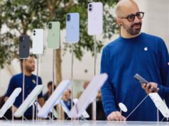 Tim Cook não descartou aumentos de preços dos produtos Apple, e aqui está o porquê Tim Cook não descartou aumentos de preços dos produtos Apple, e este é o motivo | A foto mostra funcionários conversando atrás de uma tela de iPhones em uma loja da Apple