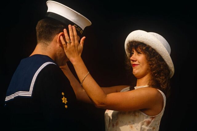 A woman with her hands on the face of her sailor husband ahead of a Buckingham Palace garden party in after sunshine in London in the United Kingdom.