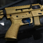 Os clientes olham para rifles estilo AR-15 em uma parede quase vazia na Rainier Arms na sexta-feira, 14 de abril de 2023, em Auburn, Washington, enquanto o estoque diminui antes de uma possível legislação que proibiria a venda futura de armas no estado. House Bill 1240 proibiria a futura venda, fabricação e importação de armas semiautomáticas do tipo assalto para o estado de Washington e entraria em vigor imediatamente após ser assinado pelo governador Jay Inslee. (Foto AP/Lindsey Wasson)