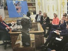 Trump trolla os líderes mundiais novamente ao compartilhar novamente a foto do mapa que mostra Canadá, Groenlândia e Venezuela, todos parte dos EUA Donald Trump falando aos líderes europeus com um mapa mostrando a bandeira dos EUA sobreposta à América do Norte e partes da América do Sul ao fundo.