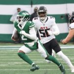 O quarterback do New York Jets, Tyrod Taylor (2), corre a bola enquanto o lado defensivo do Atlanta Falcons, Leonard Floyd (56), o persegue durante o primeiro tempo, quando o New York Jets jogou contra o Atlanta Falcons no domingo, 30 de novembro de 2025, no MetLife Stadium em East Rutherford, NJ.