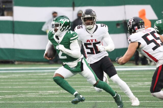 O quarterback do New York Jets, Tyrod Taylor (2), corre a bola enquanto o lado defensivo do Atlanta Falcons, Leonard Floyd (56), o persegue durante o primeiro tempo, quando o New York Jets jogou contra o Atlanta Falcons no domingo, 30 de novembro de 2025, no MetLife Stadium em East Rutherford, NJ. 