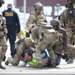 Uma pessoa levanta as mãos enquanto a polícia lança uma espessa cortina de gás lacrimogêneo na Avenida Nicollet, em Minneapolis, no sábado, 24 de janeiro de 2026. (Ben Hovland/Minnesota Public Radio via AP)
