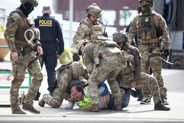 Uma pessoa levanta as mãos enquanto a polícia lança uma espessa cortina de gás lacrimogêneo na Avenida Nicollet, em Minneapolis, no sábado, 24 de janeiro de 2026. (Ben Hovland/Minnesota Public Radio via AP)
