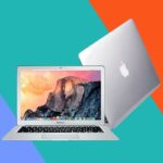 Um laptop MacBook prateado parcialmente aberto com o logotipo da Apple visível na tampa.