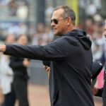 O técnico do New York Yankees, Aaron Boone, acena para o técnico do New York Mets, Carlos Mendoza.