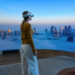 M5 Vision Pro chega às lojas em mais dois países | Foto promocional da Apple mostrando uma mulher desfrutando de uma vista envolvente da cidade