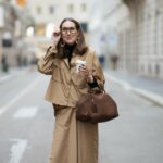 Anna Wolfers vista vestindo um suéter de malha roxo, um vestido midi azul claro com estampa floral e salto laranja claro em 02 de junho de 2022 em Hamburgo, Alemanha.