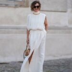 SIBIU, ROMÊNIA - 27 DE JULHO: Cosmina Pasarin usa óculos escuros, um vestido midi azul pastel com gola baixa, uma bolsa vermelha, sandálias marrons com plataforma de vime bege, em 27 de julho de 2021 em Sibiu, Romênia. (Foto de Edward Berthelot/Getty Images)