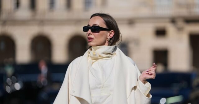 PARIS, FRANÇA - 02 DE MAIO: Alba Garavito Torre usa óculos escuros pretos, cabelo castanho longo e liso com uma parte central, uma blusa branca pregueada peplum sem mangas da Commense e jeans azul de cintura alta com bainha crua. Uma sandália tamanco amarela com detalhes florais da AGL é usada, combinada com um jeans jeans e uma mini bolsa Jackie marrom da Gucci. Os acessórios incluem um colar grosso com pedras naturais coloridas da Sempiterno Paris e joias de ouro. Foto de corpo inteiro, durante uma sessão de fotos de moda de rua, em 02 de maio de 2025 em Paris, França. (Foto de Edward Berthelot/Getty Images)