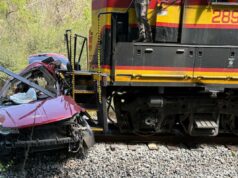 5 mortos após trem de carga atingir van em cruzamento ferroviário na zona rural do Mississippi Uma van vermelha gravemente danificada ao lado de um trem de carga nos trilhos.
