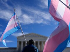 A Suprema Corte impede a Califórnia de aplicar regras para impedir que as escolas digam aos pais quando seus filhos se declaram transgêneros Um manifestante segura duas bandeiras do orgulho transgênero durante um protesto em frente à Suprema Corte dos EUA.