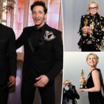 Jessie Buckley segurando uma estatueta dourada do Oscar enquanto fotógrafos tiram fotos.