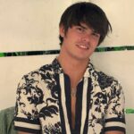 Seth Peterson sorrindo em uma mesa com comida e bebida.