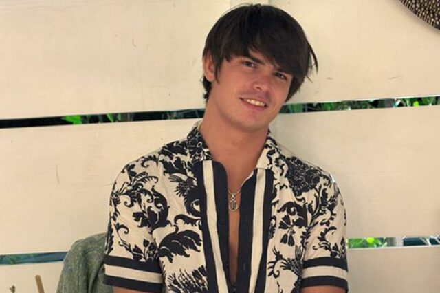 Seth Peterson sorrindo em uma mesa com comida e bebida.