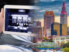 A expansão dos jogos de azar em Ohio levanta preocupações com a proteção do consumidor após um preocupante scorecard de segurança A expansão dos jogos de azar em Ohio levanta preocupações com a proteção do consumidor após um preocupante scorecard de segurança. Imagem composta mostrando uma pessoa segurando um tablet exibindo uma interface de cassino online próximo ao horizonte de Cleveland, Ohio, representando jogos de azar digitais no estado.