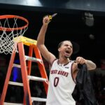 O guarda do Saint Mary, Mikey Lewis (0), vai para a cesta contra o guarda do Gonzaga, Mario Saint-Supery, à direita, durante o segundo tempo de um jogo de basquete universitário da NCAA em Moraga, Califórnia, sábado, 28 de fevereiro de 2026. (AP Photo / Tony Avelar)