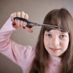 Criança cortando o próprio cabelo