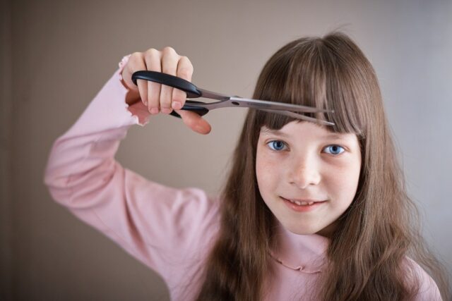 Criança cortando o próprio cabelo