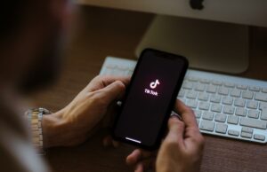 A melhor maneira de consertar seu algoritmo TikTok quando seu FYP está fora de controle Uma pessoa segurando um iPhone com o logotipo do TikTok na tela.