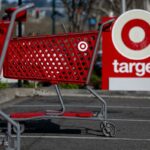 Carrinhos de compras vermelhos com o logotipo da Target na frente de uma placa da loja Target.