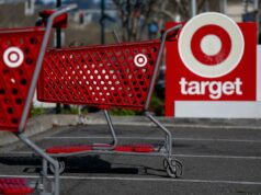 A meta reduz os preços de 3.000 itens ‘entre vestuário, itens essenciais e casa’, já que a inflação permanece acima da meta do Fed Carrinhos de compras vermelhos com o logotipo da Target na frente de uma placa da loja Target.