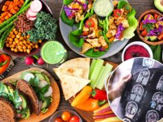 A popular ‘comida saudável’ estava na verdade associada a um declínio cerebral mais rápido, surpreendendo especialistas Uma variedade diversificada de itens de almoço saudáveis, incluindo uma tigela de Buda, wraps de alface, sanduíches, salada, homus, vegetais e um smoothie verde em um fundo de madeira.