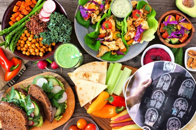 Uma variedade diversificada de itens de almoço saudáveis, incluindo uma tigela de Buda, wraps de alface, sanduíches, salada, homus, vegetais e um smoothie verde em um fundo de madeira.