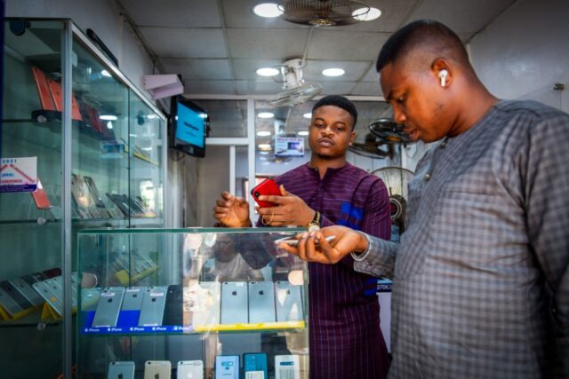 A customer browses mobile phone handsets inside a shop at the Ikeja computer village market in Lagos, Nigeria, on Monday, March 29, 2021.