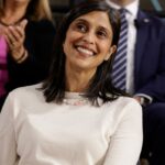 A segunda-dama dos EUA, Usha Vance, sorrindo, olhando para cima e para a direita.