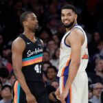 Karl-Anthony Towns, central do New York Knicks, sorrindo para o atacante do San Antonio Spurs, Harrison Barnes.