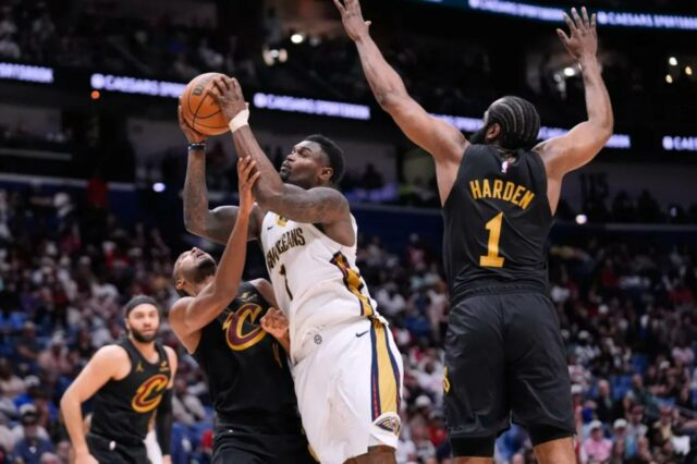 Zion Williamson (1) vai para a cesta contra o pivô Evan Mobley (4) do Cleveland Cavaliers e o guarda James Harden (1) no segundo tempo de um jogo de basquete da NBA, sábado, 21 de março de 2026, em Nova Orleans.