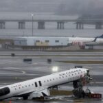 Um caminhão de bombeiros danificado no local depois que um jato da Air Canada Express colidiu com um veículo terrestre no Aeroporto LaGuardia, em Nova York, no Queens