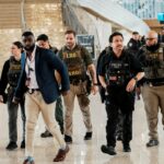 Um agente federal de imigração patrulha o Aeroporto Internacional John F. Kennedy (JFK), no bairro de Queens, em Nova York,