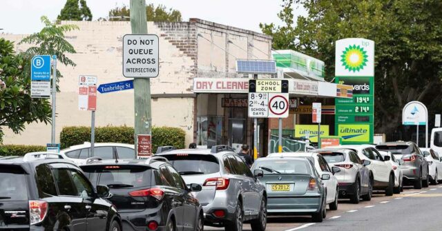 Carros fazendo fila em frente a um posto de gasolina em Mascot, Sydney.