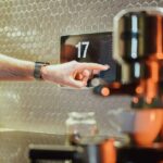 As falhas da casa inteligente da Ikea apontam para um problema com o padrão Matter | Foto de alguém usando uma tela sensível ao toque em uma cozinha ao lado de uma máquina de café