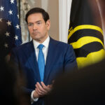 Um oficial da Alfândega e Proteção de Fronteiras verifica o passaporte de um visitante não residente nos Estados Unidos dentro do controle de imigração no Aeroporto Internacional McCarran, terça-feira, 13 de dezembro de 2011, em Las Vegas. A US Travel Association está pressionando o Congresso para facilitar a visita de estrangeiros aos Estados Unidos. Quase 7,6 milhões de vistos de não-imigrante foram emitidos em 2001, em comparação com menos de 6,5 milhões em 2010. Os líderes do turismo nos Estados Unidos dizem que o declínio simboliza um fracasso diplomático que está a custar às empresas americanas 859 mil milhões de dólares em receitas inexploradas. (Foto AP/Julie Jacobson)