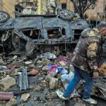 Um homem remove itens em sacos plásticos no local dos ataques aéreos israelenses noturnos nos subúrbios ao sul de Beirute, em 16 de março de 2026.