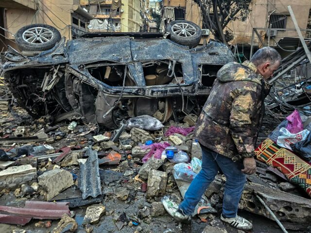 Um homem remove itens em sacos plásticos no local dos ataques aéreos israelenses noturnos nos subúrbios ao sul de Beirute, em 16 de março de 2026.