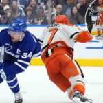 Toronto Maple Leafs Auston Matthews (34) é ferido por Anaheim Ducks Radko Gudas (7) durante um jogo de hóquei.